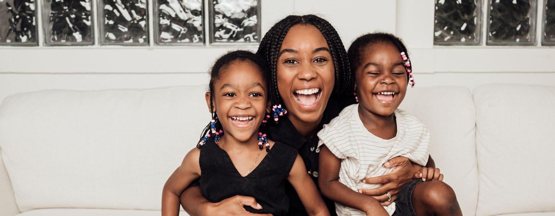 a woman sitting on a couch with two kids